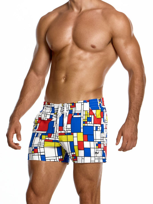 Man wearing colorful geometric patterned swim shorts on a white background