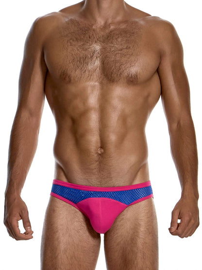 A man wearing low-rise swim briefs with a bright pink front pouch and a blue mesh side panel, shown against a plain white background.