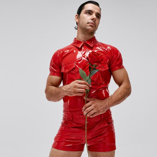 Model wearing red vinyl latex look outfit by Modus Vivendi, holding a red rose