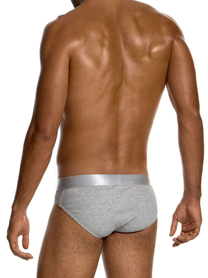Rear view of a muscular man wearing light gray heathered briefs with a metallic silver waistband, set against a plain white background.