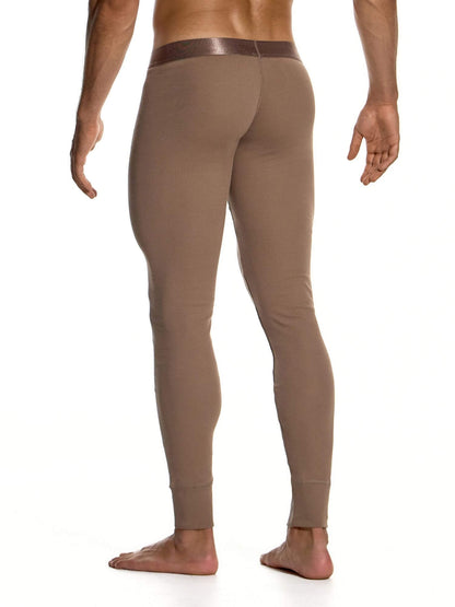 A man shown from the back wearing tight-fitting, full-length brown leggings or compression pants against a plain white studio background.