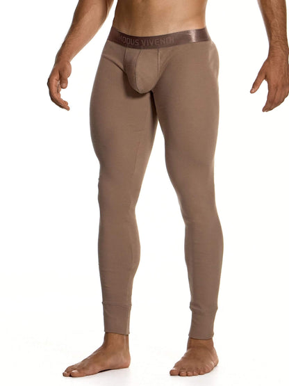A man wearing tight-fitting, form-fitting, full-length underwear in a taupe-brown color, shown from the waist down against a plain white background. The brand name  is visible on the waistband.