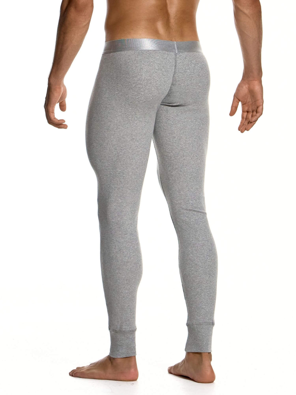 A man shown from the back wearing light gray heathered compression or base-layer leggings with a metallic silver-gray waistband, standing barefoot against a white background.