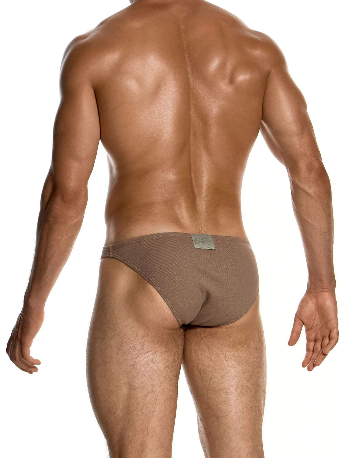 Rear view of a muscular man wearing low-rise brown briefs against a solid white background.