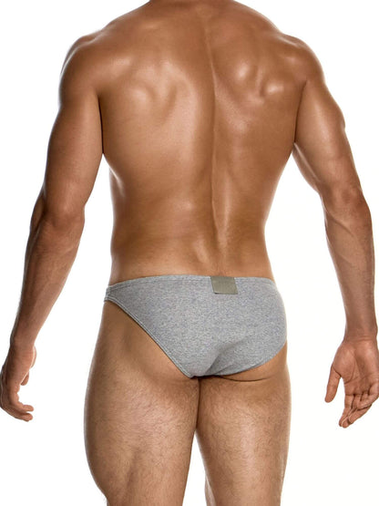 Rear view of a muscular man wearing heather gray briefs against a plain white background.