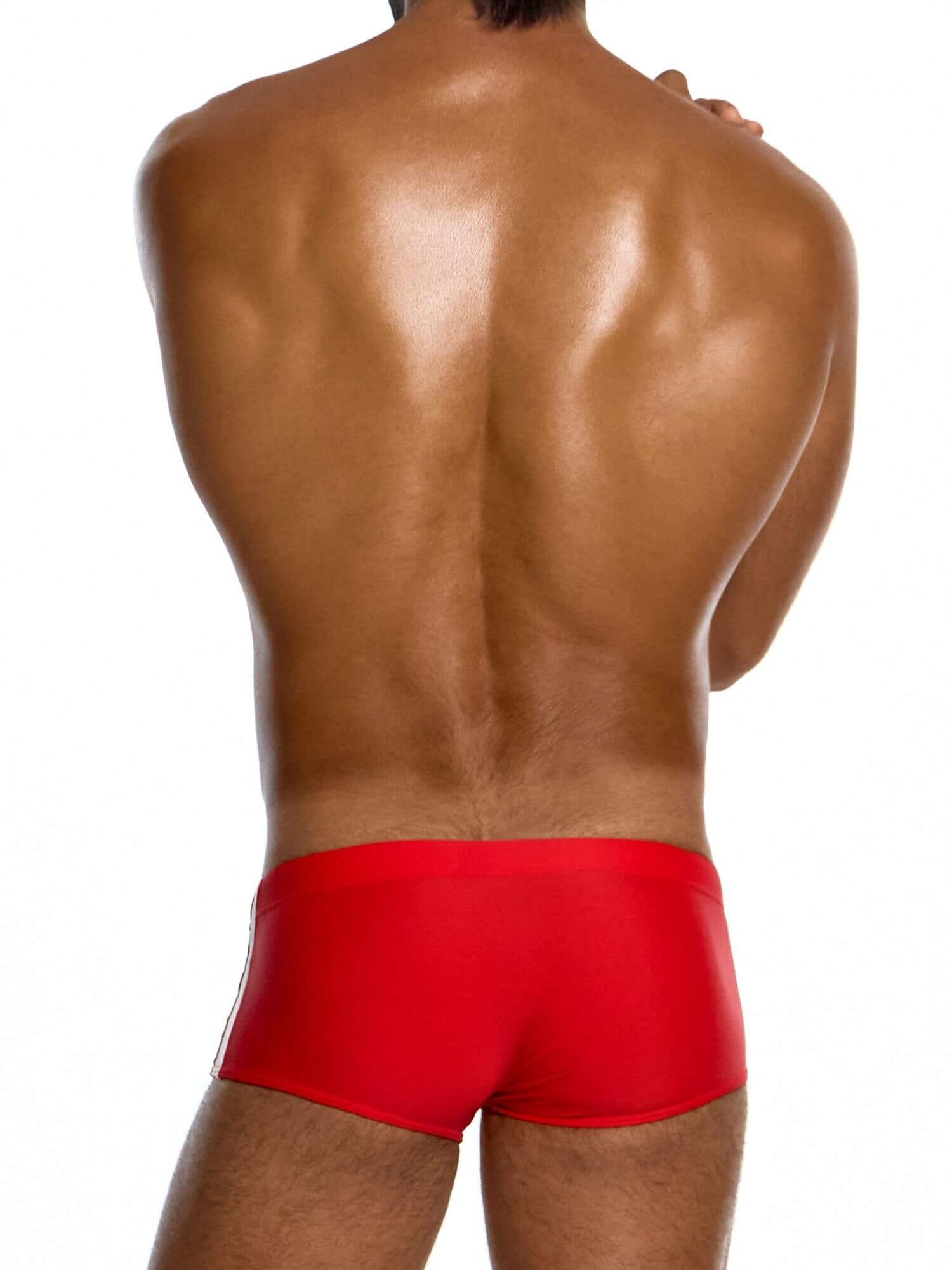 Red swim trunks worn by a person on a white background