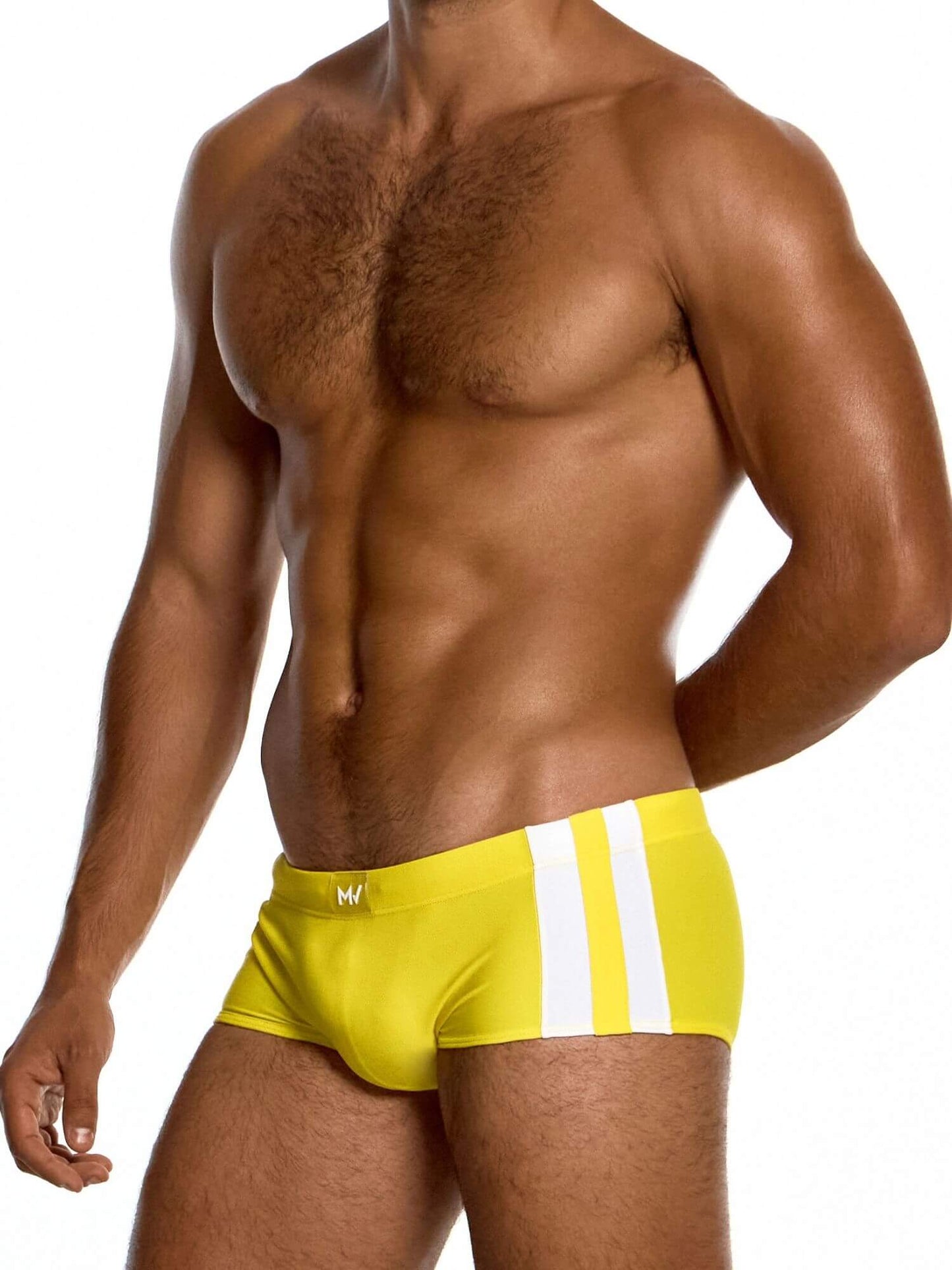 Man wearing bright yellow swim briefs with a white stripe on a white background