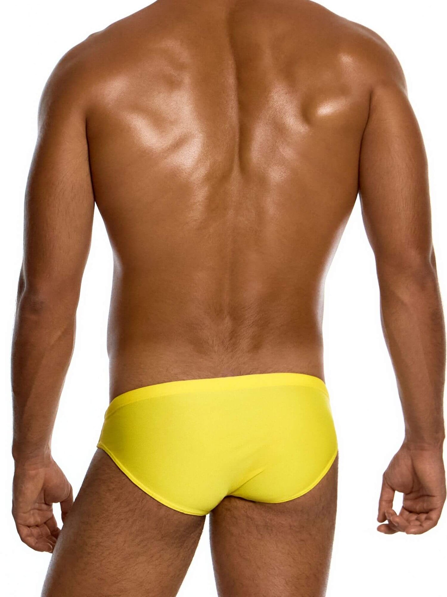 Person wearing bright yellow swim briefs on a white background