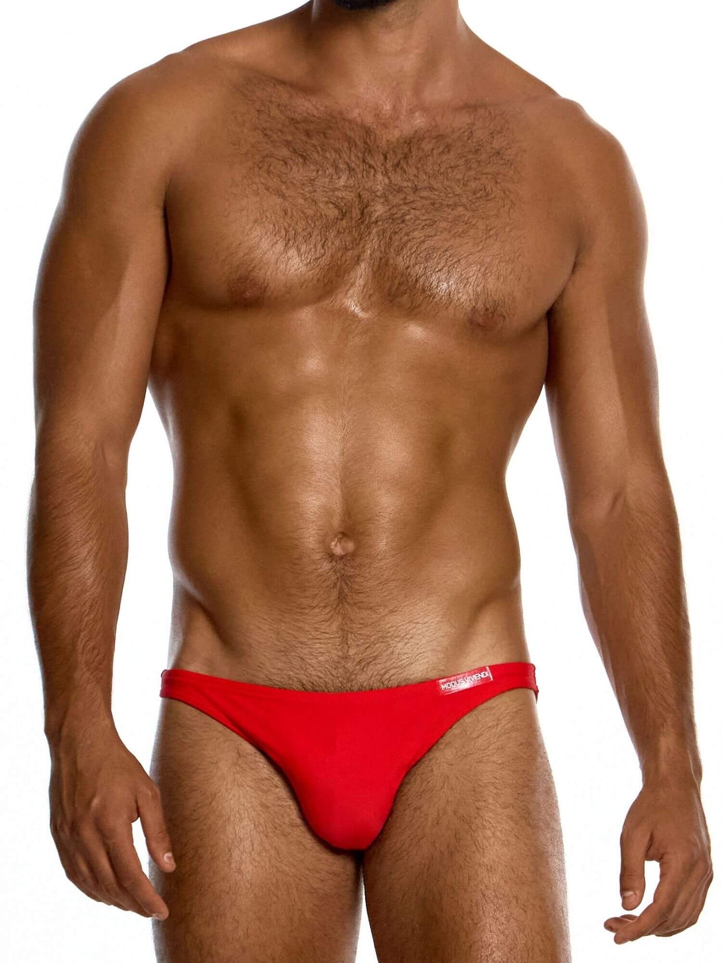 Man wearing a red men's swimming bikini on a white background
