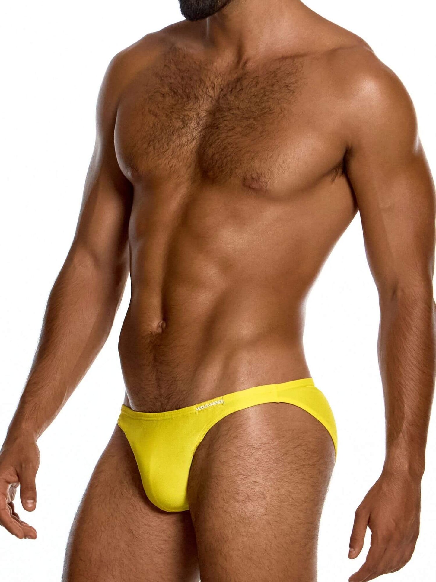 Man wearing a bright yellow swim brief on a white background
