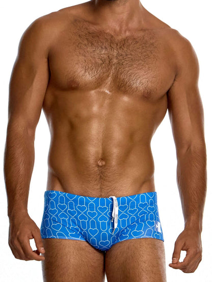 Man wearing blue swim trunks with a geometric pattern on a white background