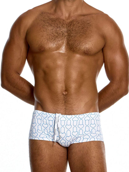 Man wearing white swim trunks with blue geometric pattern on a white background