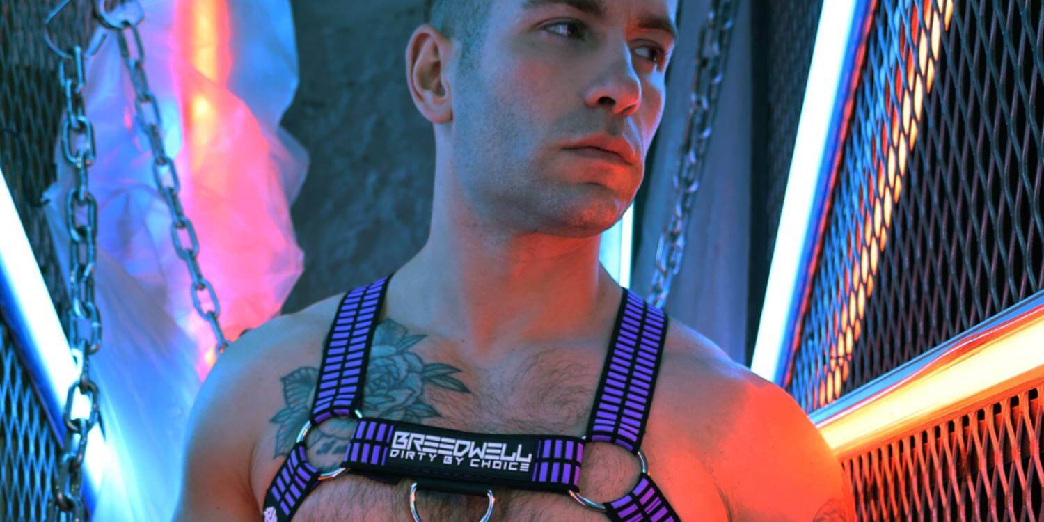 Man wearing a harness with neon lights in the background
