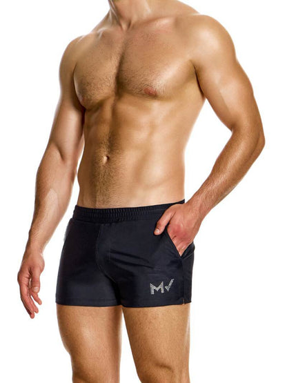 A man wearing black short-legged swim shorts with pockets, featuring the Modus Vivendi branding.