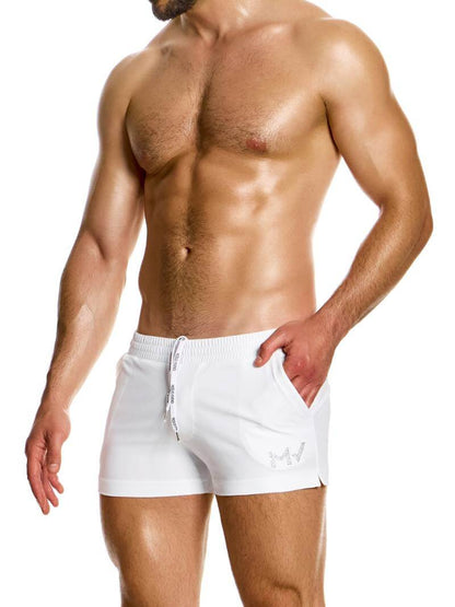 A man wearing black short-legged swim shorts with pockets, featuring the Modus Vivendi branding.