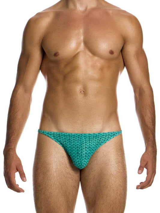 A male model wearing a Modus Vivendi Illusion Sheer Thong with a two-tone contrasting color intricate print in black/grey.