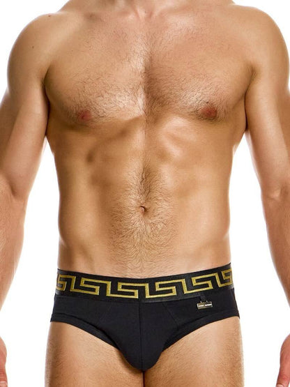 A model wearing a blue brief with a Meander Greek Key print waistband, part of the Modus Vivendi collection.