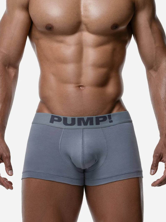 Man wearing gray boxer briefs with 'PUMP!' waistband on a plain background