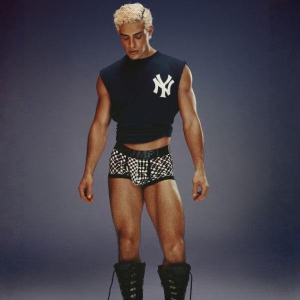 Man wearing a black sleeveless shirt with a logo and PUMP! Glitch checkered underwear on a dark background