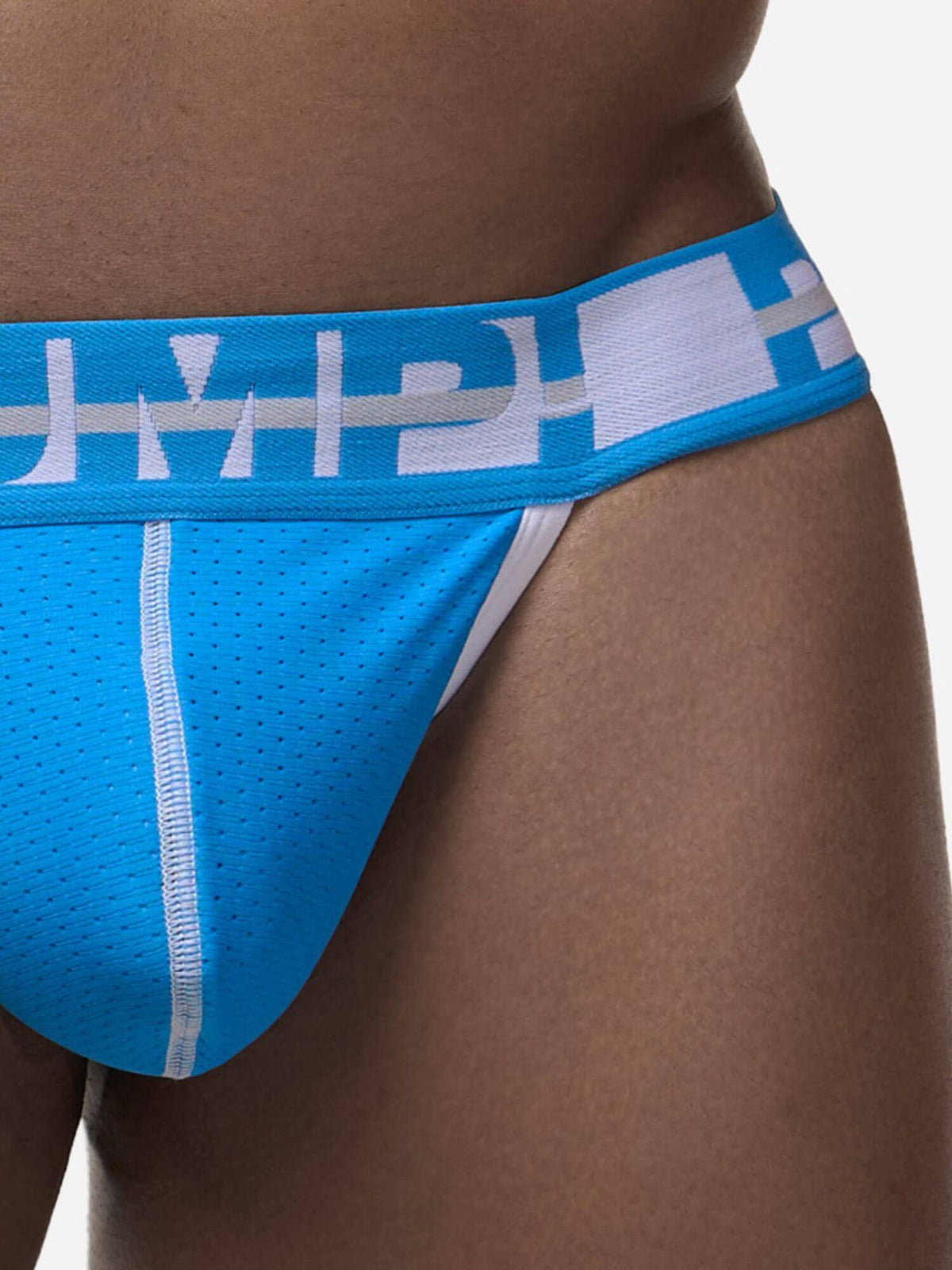 Close-up of a person wearing bright blue athletic briefs with a white logo pattern on the waistband and white piping details.