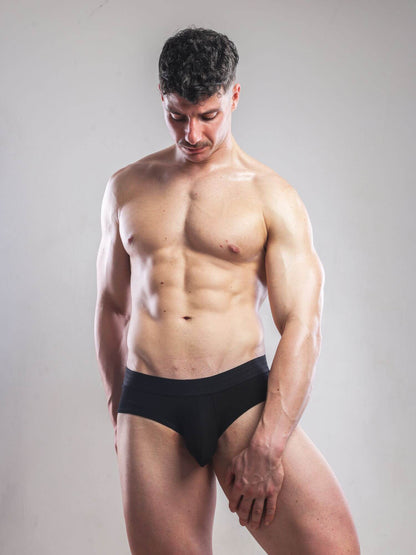 Man wearing a black underwear set against a plain background
