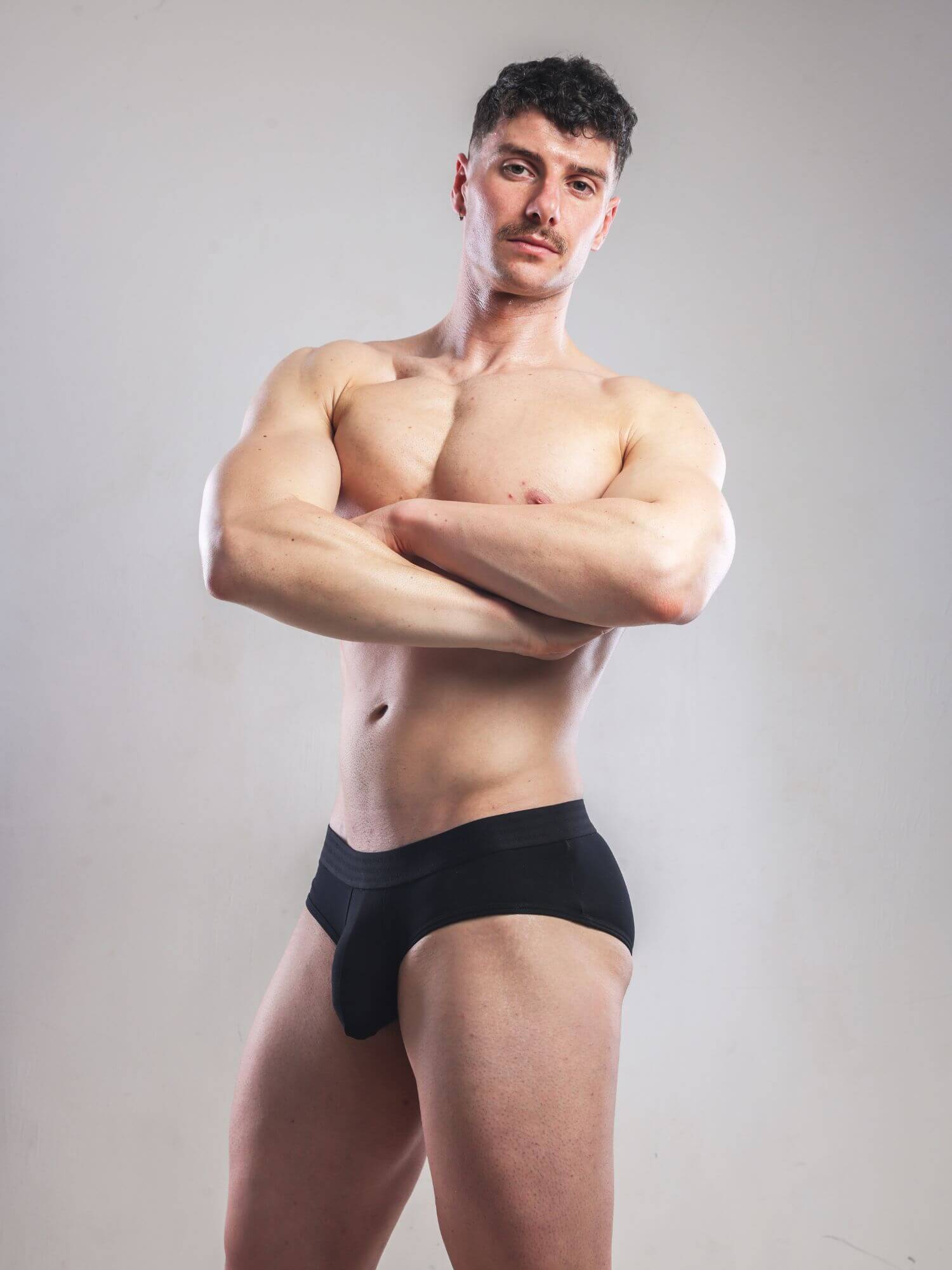 Man wearing a black underwear against a plain background