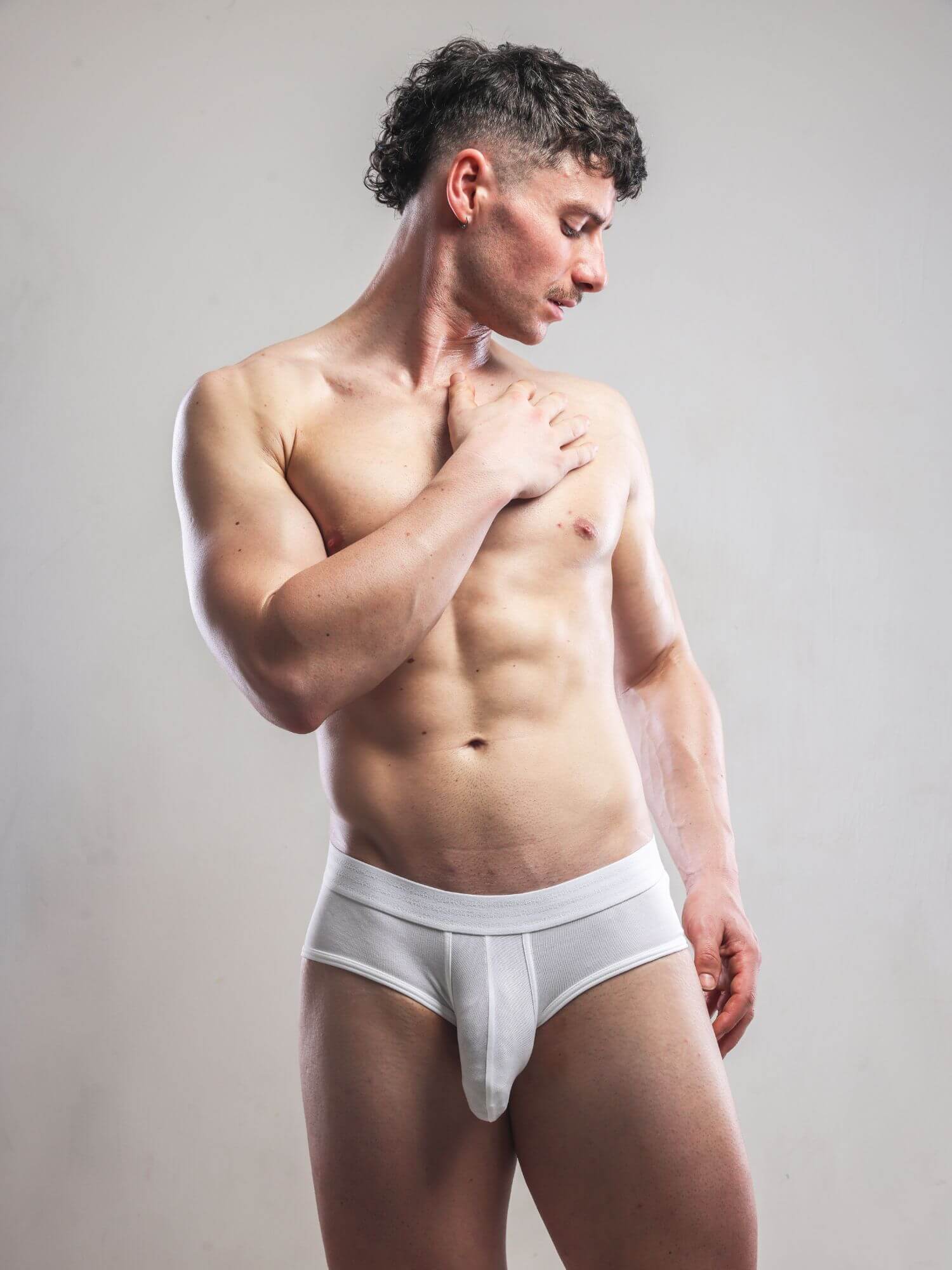 Man wearing a white underwear set against a plain background