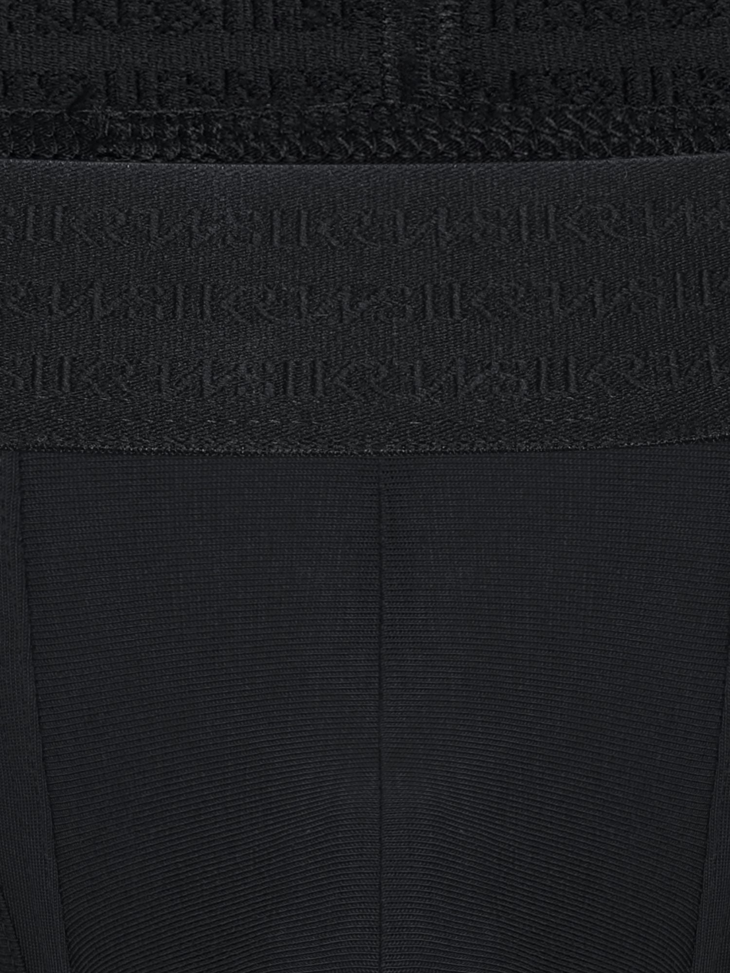 Close-up of a black ribbed knit garment with a wide waistband featuring an embossed repeating SUKREW logo pattern.