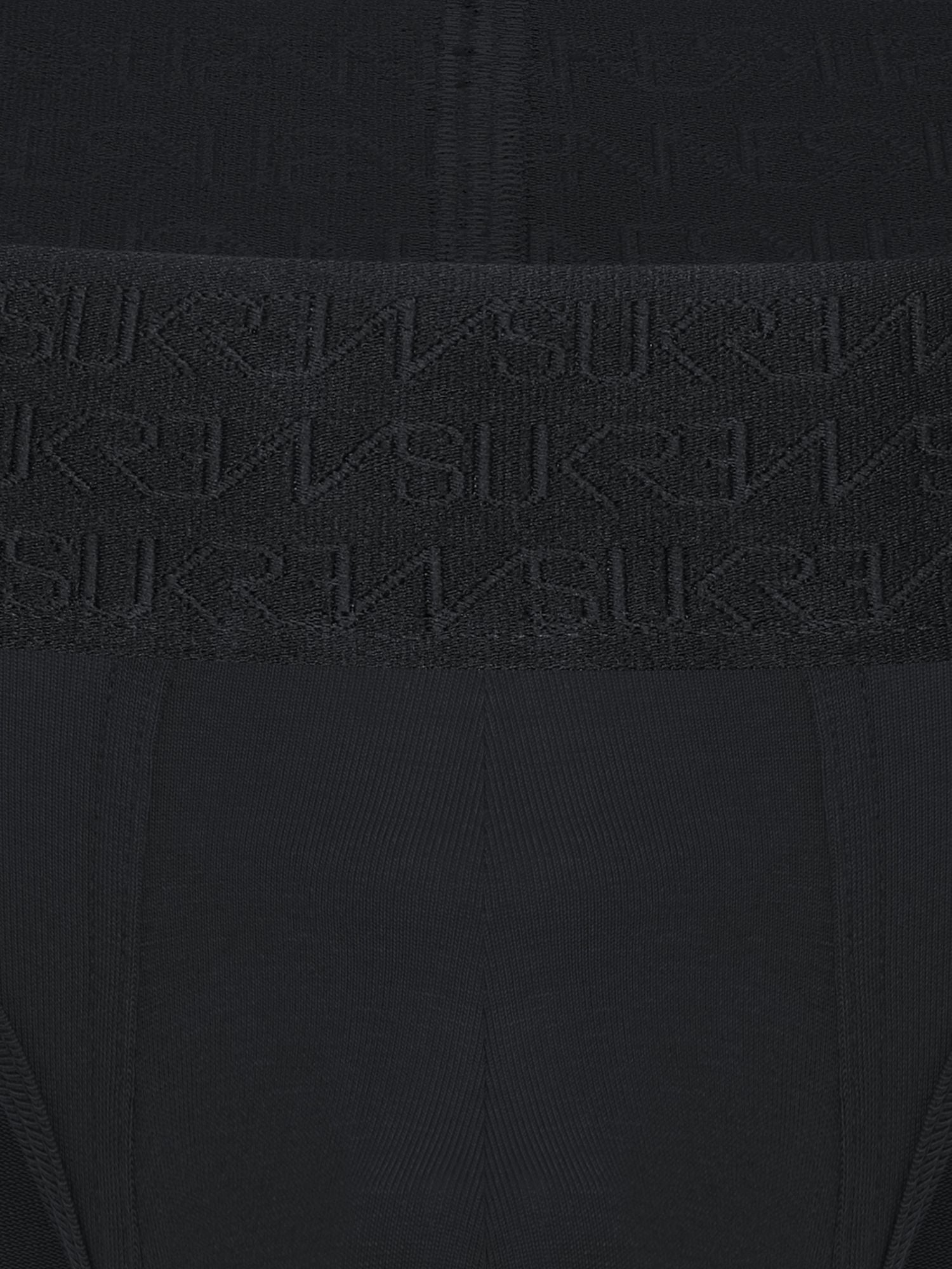 Close-up of a black ribbed knit garment with a wide waistband featuring an embossed repeating SUKREW logo pattern.