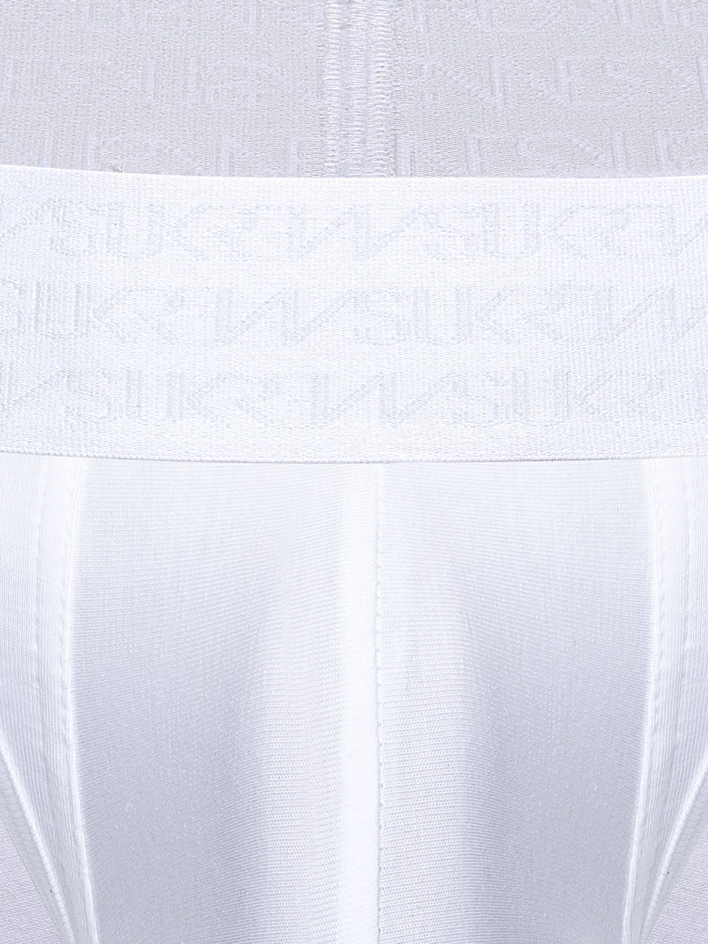 Close-up of a white underwear or garment waistband with a repeating tonal SUKREW logo pattern, shown against matching white fabric.