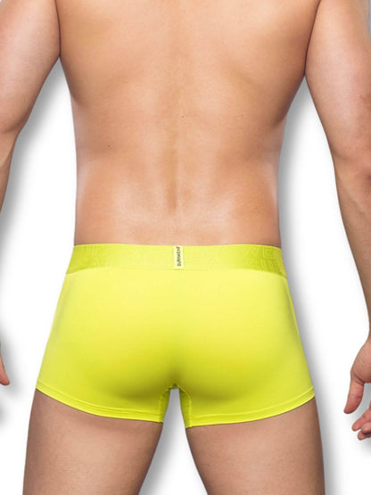 Person wearing bright neon lime boxer briefs on a white background
