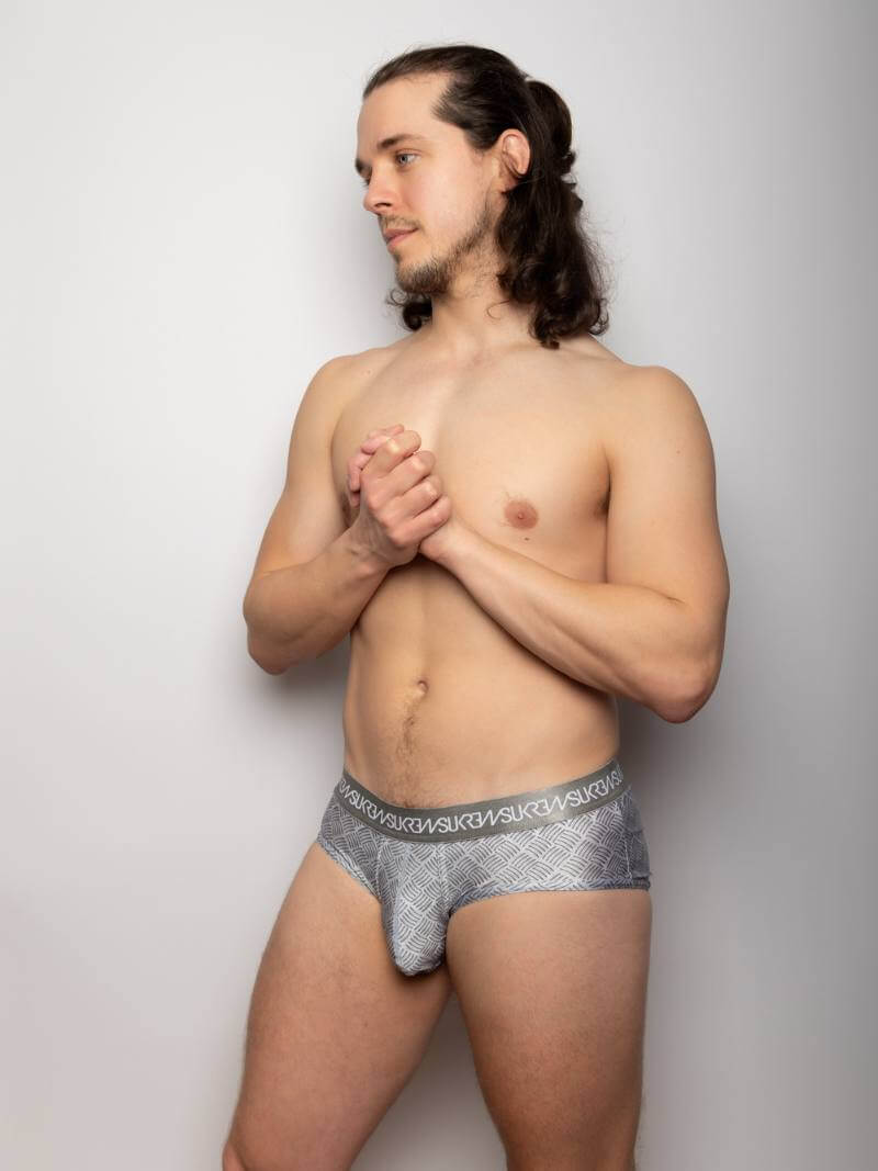 Man wearing gray underwear against a plain background