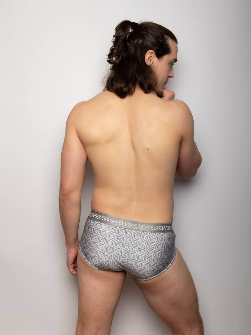 Man wearing gray underwear with a subtle pattern on a plain background