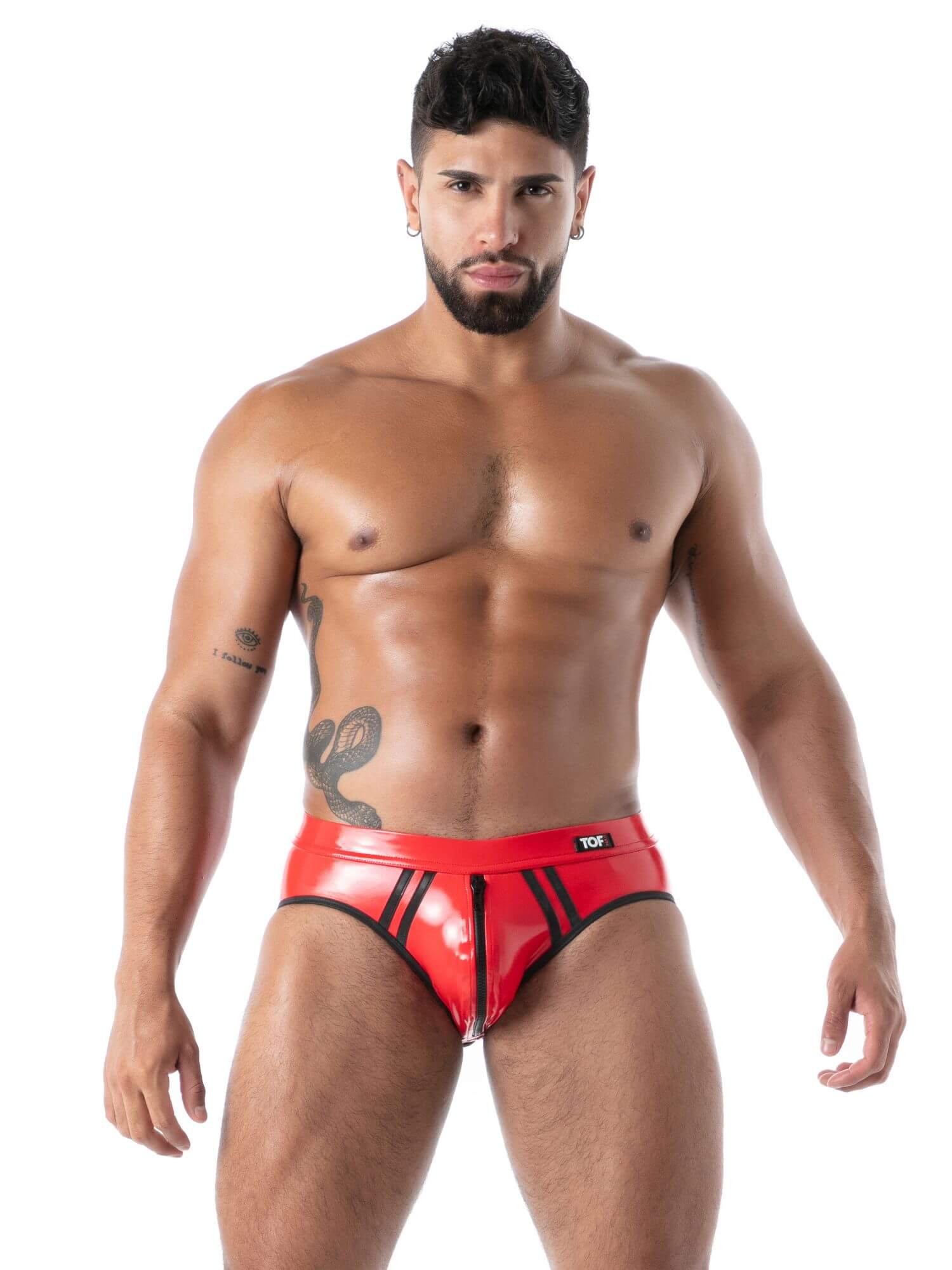 Man wearing red latex bottomless briefs on a white background