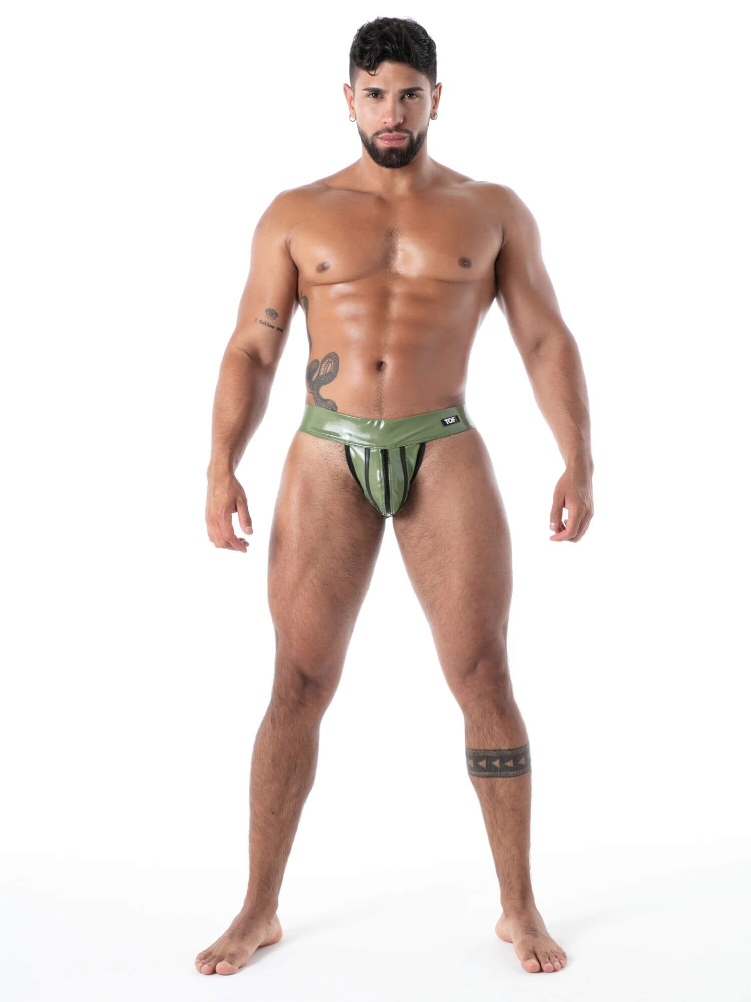 Man wearing a green latex jockstrap underwear on a white background