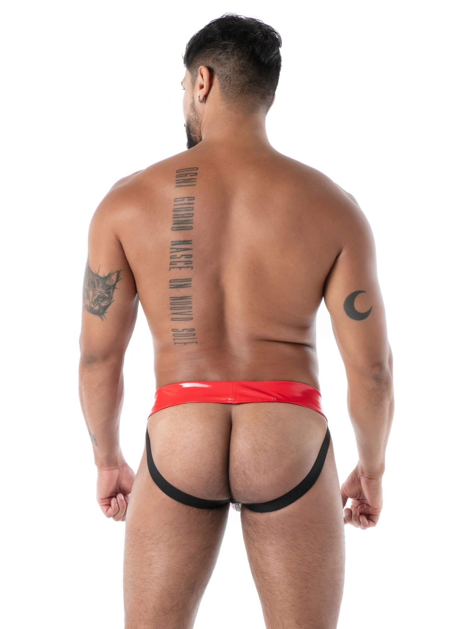 Man wearing a red and black latex jockstrap on a white background