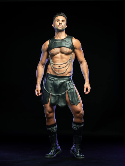 A muscular man modeling a black leather-style costume set consisting of a sleeveless top, matching skirt, and layered chain details, standing against a solid black background.