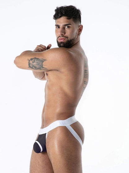 Man wearing a black and white jockstrap against a white background