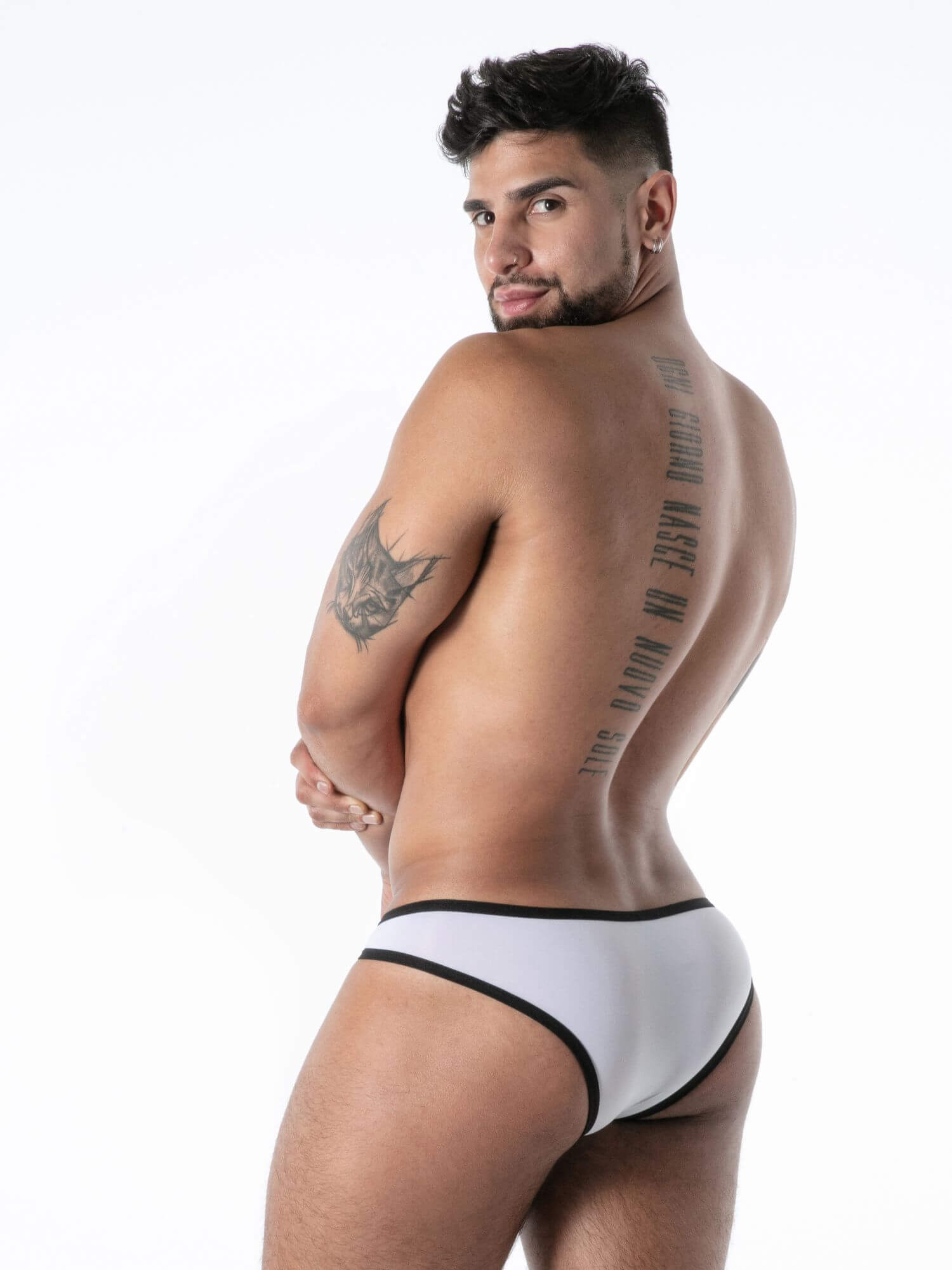 Man wearing a white thong with black trim on a white background
