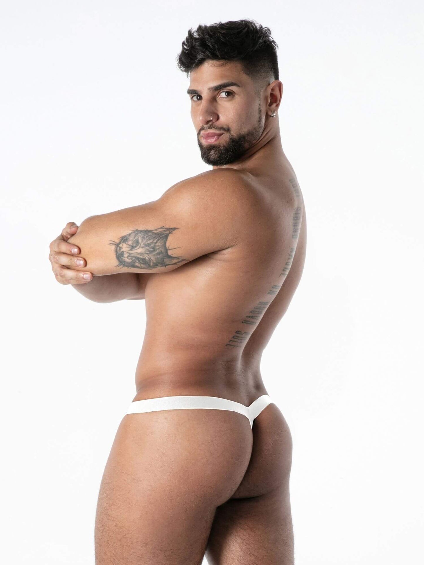 Man wearing a white thong against a white background