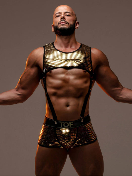 Man wearing a gold TOF Paris Glitter partywear outfit against a brown background