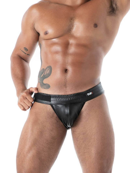 Man wearing a black leather jockstrap on a white background
