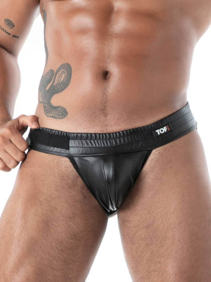 Man wearing a black leather jockstrap on a white background