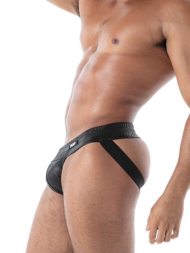 Man wearing a black leather jockstrap on a white background
