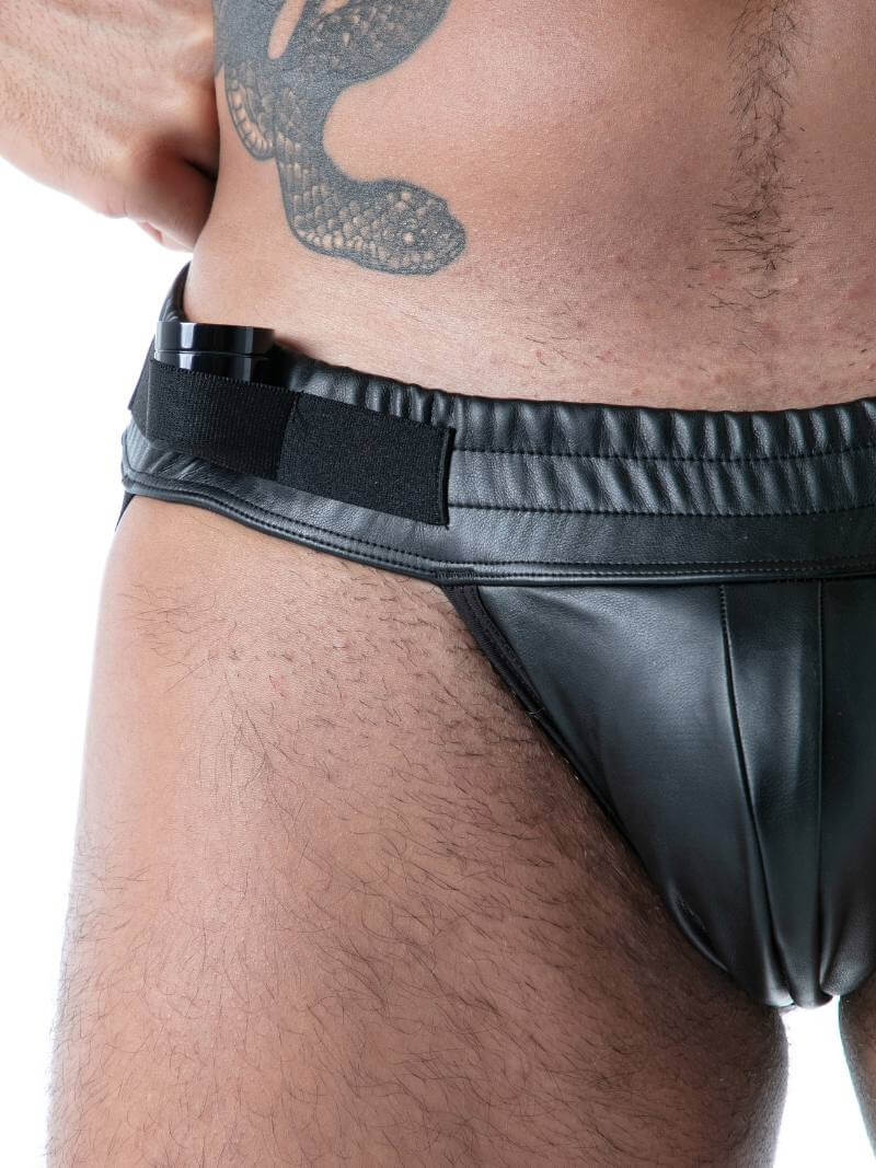 Man wearing a black leather jockstrap on a white background