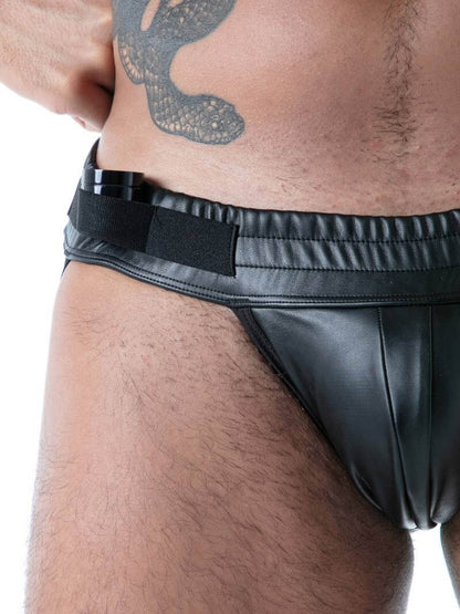 Man wearing a black leather jockstrap on a white background