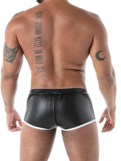 Man wearing black leather shorts with tattoos on his back and arms.