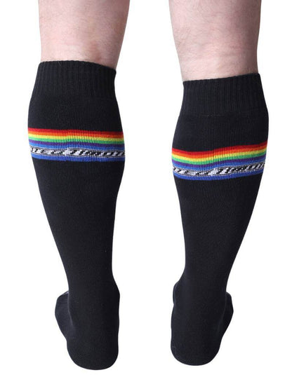 Black socks with rainbow stripes worn by a person on a white background