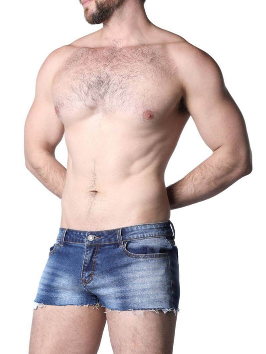 Man in denim shorts and a white knit shirt on a beach with palm trees and mountains in the background.