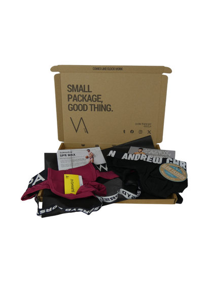 Cardboard box with 'Small Package, Good Thing' text, containing underwear and a magazine on a white background.